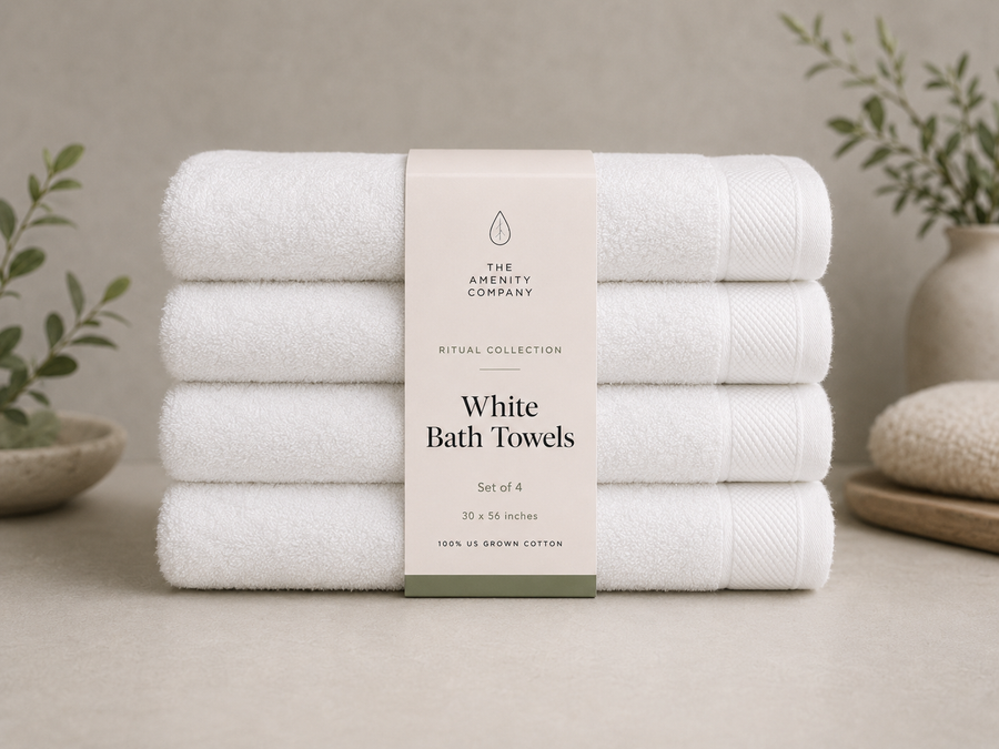 Folded stack of white bath towels with a Ritual Collection belly band